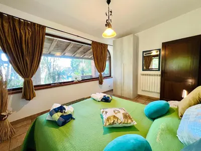 a bedroom with two beds and a large window at Villa Ólea Resort in Carini