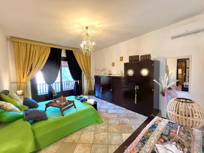 a living room with a green bed and a table at Villa Ólea Resort in Carini