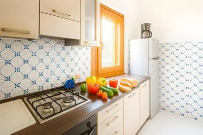 a kitchen with a stove and vegetables on the counter at Green House con piscina privata 7 posti in Macari
