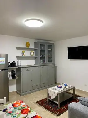 a living room with a kitchen with a table and a tv at La mia Casetta al Politeama in Palermo