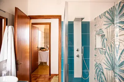 a bathroom with a shower with blue tiles at Villa Stella in Alcamo