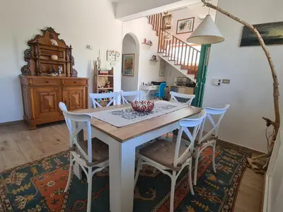 a kitchen and dining room with a table and chairs at B&B Ondamarina in Lascari