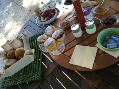 a wooden table with pastries and bread on it at B&B Ondamarina in Lascari