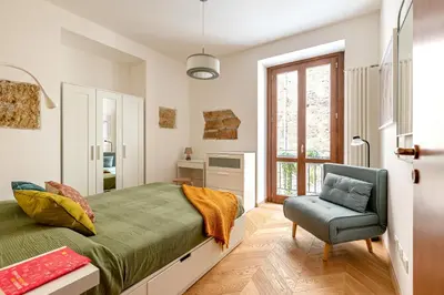 a bedroom with a bed and a chair and a window at Casa Dolce Vita by Wonderful Italy in Palermo