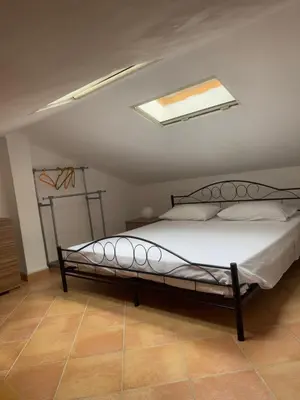a bedroom with a bed with a skylight at Villetta giardino, piscina, mare in Campofelice di Roccella