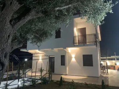 a white building with a large tree in front of it at Trabia Casa Bianca B in Mandra Capreria