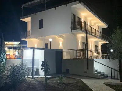 a large white house with a balcony at night at Trabia Casa Bianca B in Mandra Capreria