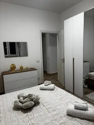 a white bedroom with two towels on a bed at Casa Sulia in Terrasini