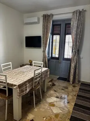a dining room with a table and chairs and a tv at Casa Sulia in Terrasini