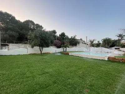a backyard with a swimming pool and a grass field at Le Onde della Sicciara in Balestrate