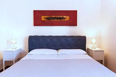 a bed with a blue headboard and two night stands at Villa Palme in Alcamo Marina