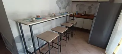 a kitchen with a bar with stools and a table at Villa Alba in Palermo