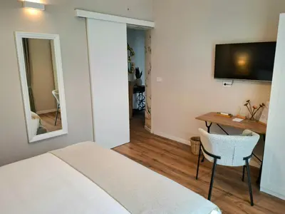 a bedroom with a bed and a desk and a television at MAGGESE Dimora di Charme in Palermo