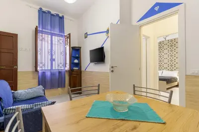 a dining room with a table and blue chairs at Ruci ruci in Mondello