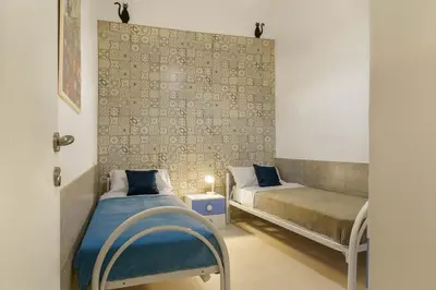 a bedroom with two beds and a bench in it at Ruci ruci in Mondello