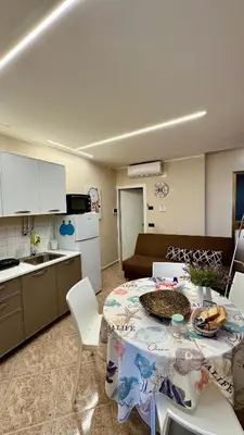 a kitchen and a table with a table cloth on it at FronteMare12 in Palermo