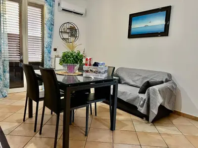 a dining room with a table and a couch at Casa Yasmine in Santa Flavia