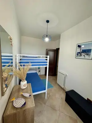 a bedroom with a bunk bed with a blue floor at Casa Yasmine in Santa Flavia