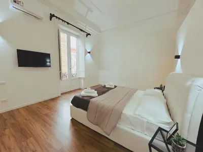 a bedroom with a bed and a flat screen tv at Candalù - Palermo Suite in Palermo