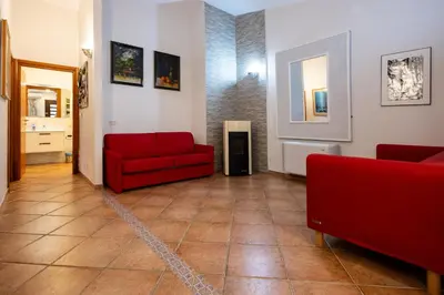 a living room with a red couch and a fireplace at Gulliver's Nest in Castellammare del Golfo