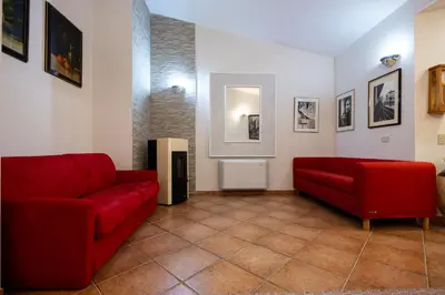 a living room with two red couches and pictures at Gulliver's Nest in Castellammare del Golfo