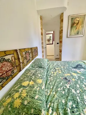 a bedroom with a bed with a floral bedspread at Bella Kalsa in Palermo
