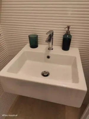 a white sink with two cups on top of it at Katia Home - San Vito lo Capo in San Vito lo Capo