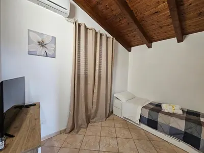 a room with a bed and a television in it at la casetta del baglio in Monreale