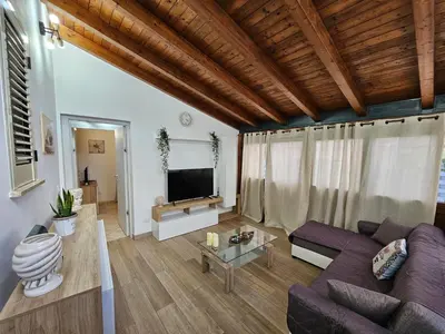 a living room with a purple couch and a tv at la casetta del baglio in Monreale