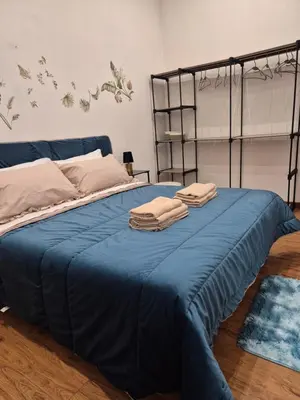 a bedroom with a bed with blue sheets and birds on the wall at La Casuzza 2 in piazzetta in Palermo