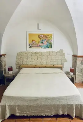 a bed in a room with a brick wall at Vucciria Holiday - Centro storico - via Emanuele in Palermo