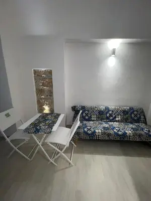 a room with a bed and a table and chairs at La Maiolica 61 in Terrasini