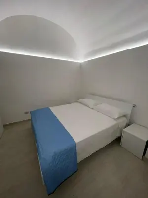 a bedroom with a bed with a blue and white blanket at La Maiolica 61 in Terrasini
