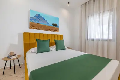 a bedroom with a large bed with green pillows at Case Vacanza Loria in Castelluzzo