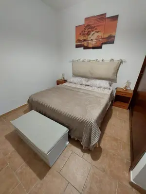 a bedroom with a bed with a table and a painting at Il Rifugio Delle Giuiuzze in Palermo