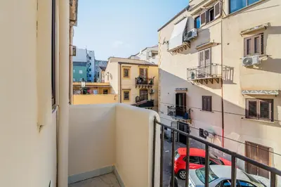 a view from the balcony of a building with a red car at GuestHost - La Rosa di Ballarò Palermo Apartment in Palermo