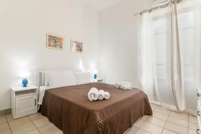 a bedroom with a bed with two towels on it at GuestHost - La Rosa di Ballarò Palermo Apartment in Palermo