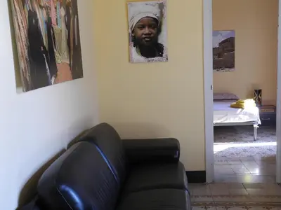a living room with a couch and a picture of a woman at Kalsa Apartment in Palermo