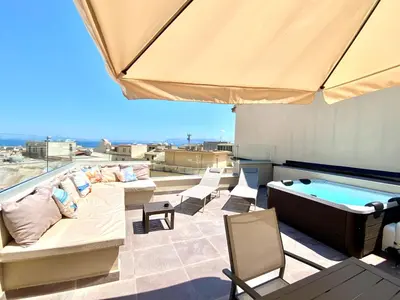 a balcony with an outdoor kitchen and a table with chairs at Gs Vacantion's del Golfo con vasca idromassaggio in Castellammare del Golfo