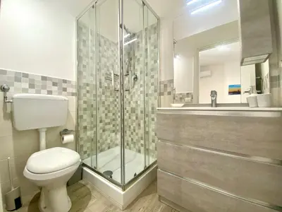 a bathroom with a toilet and a glass shower at Gs Vacantion's del Golfo con vasca idromassaggio in Castellammare del Golfo