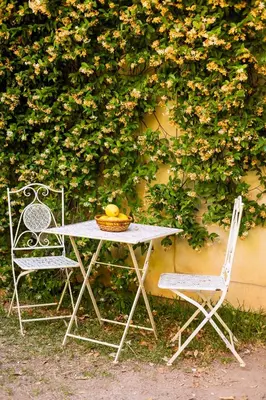 a table and two chairs in front of a wall at Principe di Castelnuovo Historical Suites in Palermo