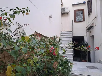 a stairway leading to a white building with flowers at La Lunetta - romantic little house in Palermo