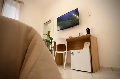 a room with a refrigerator and a tv on the wall at Front Palermo House in Palermo