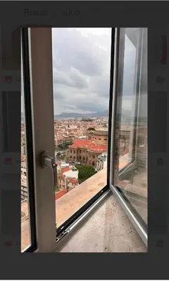 an open window with a view of a city at Clar Suite -Grattacielo in Palermo