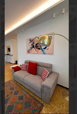 a living room with a couch and a lamp at Clar Suite -Grattacielo in Palermo