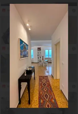 a living room with a table and a painting on a wall at Clar Suite -Grattacielo in Palermo