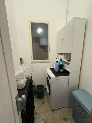 a small kitchen with a washing machine and a window at St Joseph in Terrasini