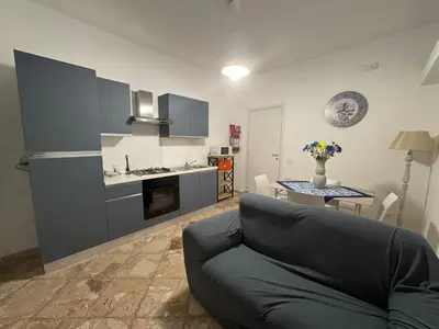 a living room with a couch and a kitchen at St Joseph in Terrasini