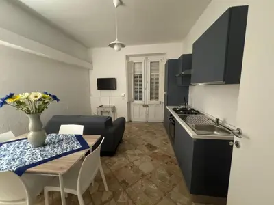 a kitchen and a living room with a table and a kitchen and a tableablish at St Joseph in Terrasini