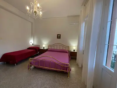 a bedroom with two beds and a chandelier at Pretty Holiday House in Palermo